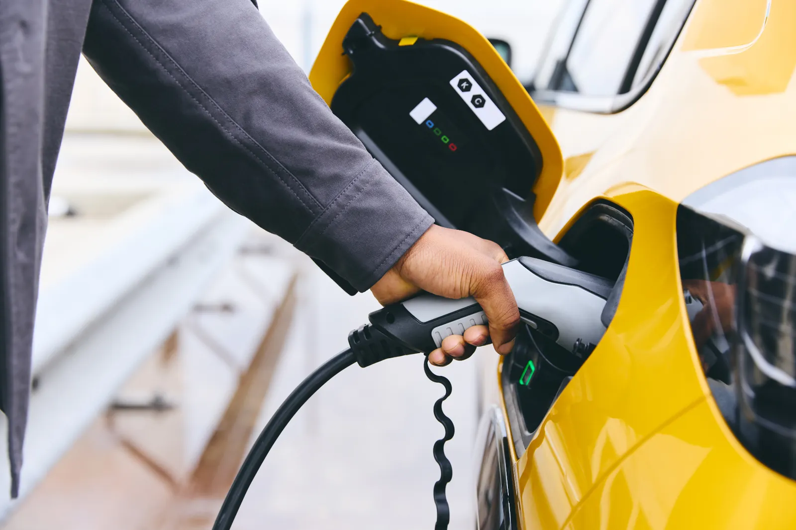 Persona cargando un auto eléctrico en casa